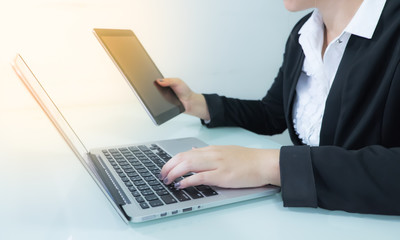 Business woman working on table with notebook and tablet