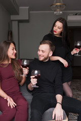 Female jealousy on party. Possessive relationship. Dissolute smiling male at party, distrust in company. Communication with wine, love triangle