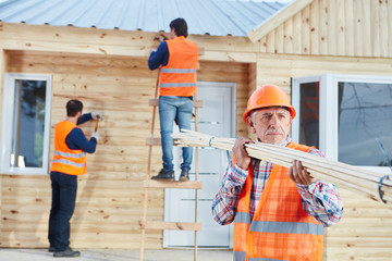 Handwerker bauen Holzhaus als Ferienhaus