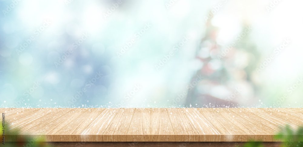 Aufkleber Empty wooden table with abstract blur christmas tree and snow falling background with bokeh,Holiday backdrop,Mock up banner for display of product for promotion online