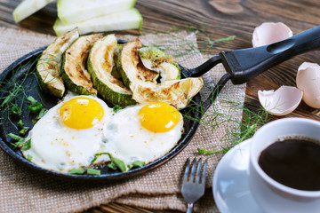 Home-made Breakfast - scrambled eggs, zucchini slices and black coffee.
