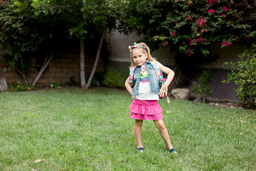 A young girl with freckles is excited and nervous for her first day of school.