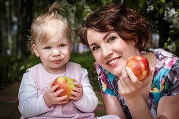 Mother and daughter with apple in the hand