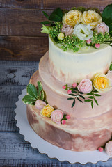 Obraz na płótnie Canvas three-tiered wedding ombre cake decorated with roses and greenery