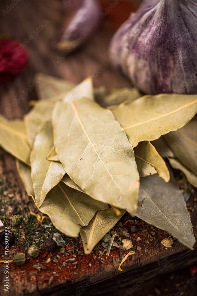 Wall mural Dried bay leaf on spicy wooden board