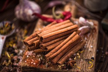 Whole cinnamon stocks on wooden boar. Spices concept