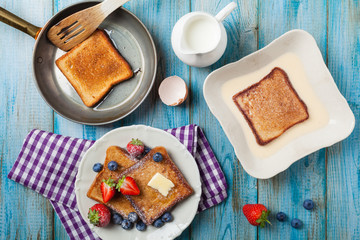 Traditional, delicious, sweet French toast with fruit and butter.