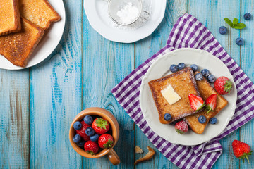 Traditional, delicious, sweet French toast with fruit and butter.