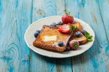 Traditional, delicious, sweet French toast with fruit and butter.