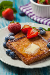 Traditional, delicious, sweet French toast with fruit and butter.