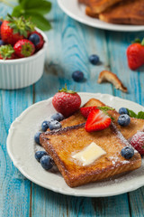 Traditional, delicious, sweet French toast with fruit and butter.