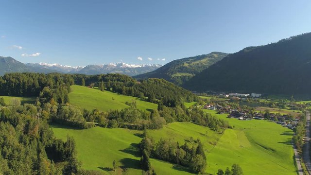  the alps over beautiful green meadows and autumn forest, stunning holiday destination in Bavaria birds eye view, 4K 