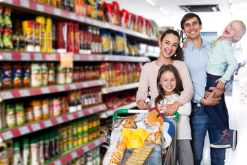 Family with two daughters shopping in local supermarket