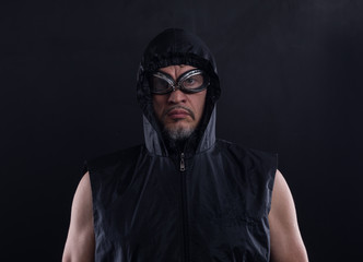 studio portrait of a man in a hood and glasses