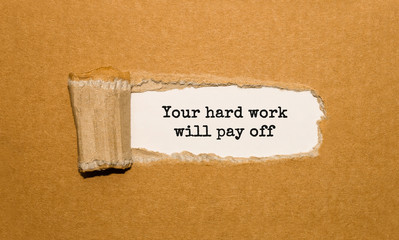 The text Your hard work will pay off appearing behind torn brown paper