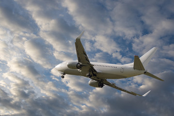 Fototapeta na wymiar Airplane flying in sky with beautiful clouds