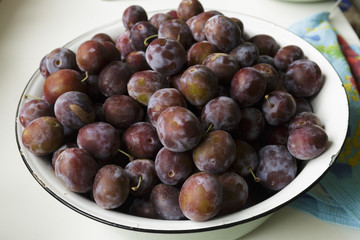 Vegan food. Fresh plum in a dish isolated.