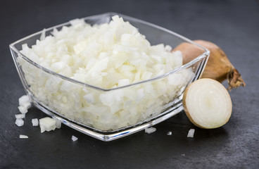 Some Chopped white onions on a dark slate slab