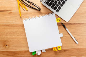 Notepad and laptop on wooden table
