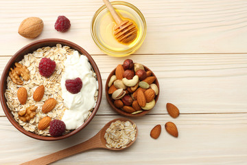 healthy breakfast. oatmeal, honey and nuts on white wooden table. Top view with copy space