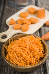 Grate  carrots in a bowl