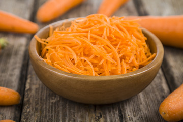 Grate  carrots in a bowl