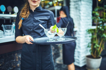 Waiters carrying plates with food, in a restaurant.