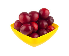Plum in a yellow plate isolated on a white background