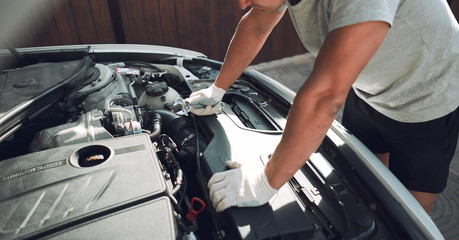 Fototapeta na wymiar Close-up. A man is fixing a car with a wrench. White car