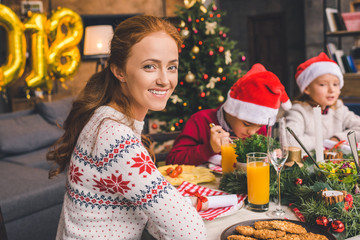 mother sitting at christmas table with kids