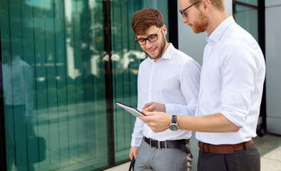 Businesspeople looking at tablet outdoors