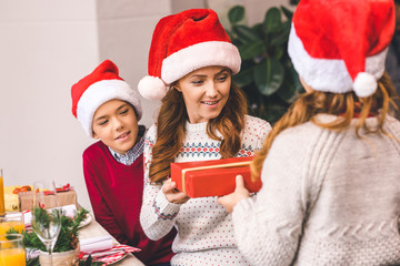 kids giving christmas present to mother