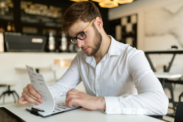 Fototapeta premium Businessman choosing from menu in restaurant
