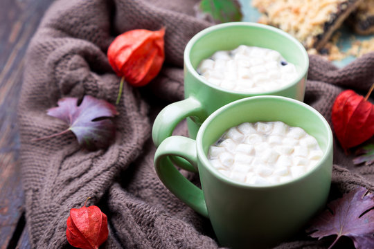 Two cup of coffee or hot chocolate with marshmallow near knitted blanket and pie. Autumn concept. Christmas.