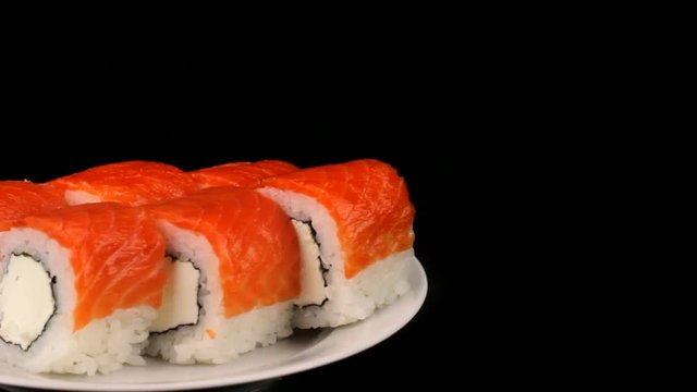 Philadelphia rolls are rotating on a plate, Japanese cuisine