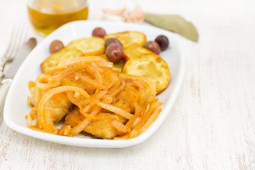 fried cod fish with onion and olive oil on dish