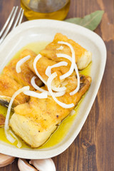 fried cod fish with onion and olive oil on dish