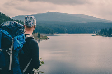 Reisen mit Camping Sachen vor einem See mit Berg