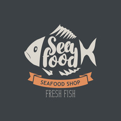Fototapeta premium Vector emblem or banner for seafood shop with decorative fish, inscription seafood and words fresh fish on the dark background in retro style.