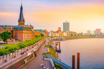 A view at the city skyline central Dusseldorf from the rhine river, Dusselfdorf Germany. Colorful panorama of german city at sunset.