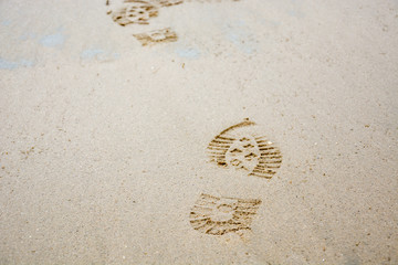 Footprints of shoes in the sand from the front