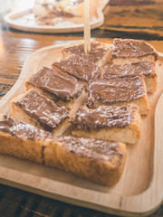 Close up chocolate topping toast on wooden plate