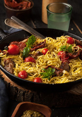 Carbonara paste with parmesan cheese and cherry tomatoes in a frying pan