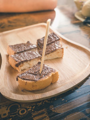Wooden stick into the chocolate on topping toast for ready to eat