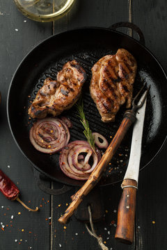 Grilled steak of pork with spices, rosemary and chili pepper in a frying pan