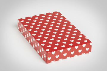 red gift box with hearts in white floating in a grey background