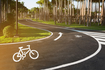 Obraz premium Bicycle symbol on bicycle lane with beautiful garden in Thailand.