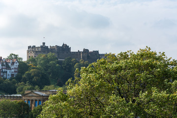 Fototapeta na wymiar Edinburgh castle behind a tree seen from Scott Monument