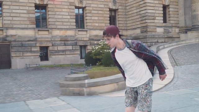 A guy is racing on a skateboard in an urban ambience