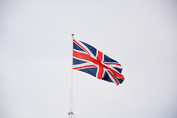 The flag of the United Kingdom on a pole and blue sky